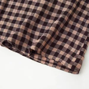 Detail view of brown and black gingham fabric with a textured weave pattern.