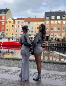 Fashionable gray knit cardigan and shorts set shown in a scenic outdoor harbor setting