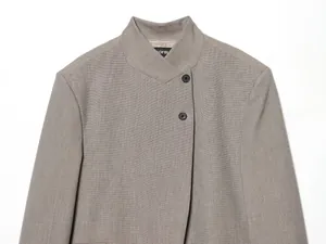 Detaillierte Nahaufnahme eines Damen-Stehkragen-Blazers mit asymmetrischem Knopfverschluss