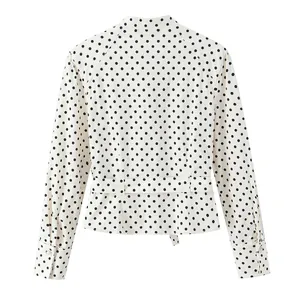 Vista trasera de una chaqueta blanca de estilo camisa con lunares negros y cinturón
