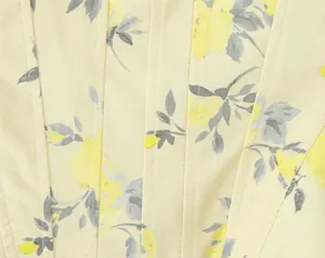Detalle de cerca de la tela con estampado floral amarillo y costuras