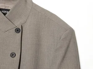 Nahaufnahme des khakifarbenen Blazers mit Stehkragen und feiner gewebter Textur
