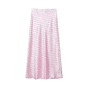 Detail van roze satijnen midi-rok met elegant zwart polkadot-patroon