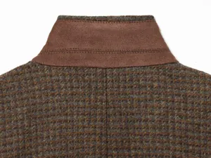 Macro view of the stand collar stitching and brown plaid fabric texture on blazer