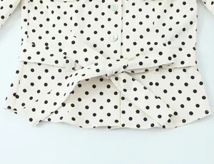 Primer plano de la cintura de una camisa de lunares con detalle de cinturón