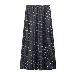Detailweergave van een zwarte satijnen midirok met witte stippen voor dames