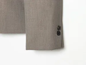 Detailaufnahme eines hochwertigen Sakkoärmels mit zwei schwarzen Zierknöpfen