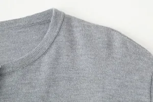 Close-up detail of the fine knit texture and ribbed neckline of a gray cardigan.
