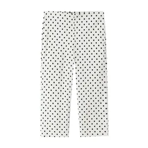 Vista detallada de un pantalón blanco de pierna ancha con clásico estampado de lunares