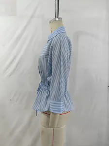 Detailed side view of a fashionable blue striped long sleeve shirt with an elegant bow waist