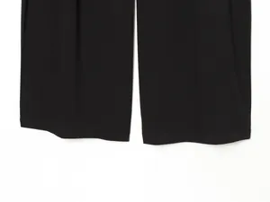 Detailed view of flat stitched hems on black wide-leg bucket pants for women's fashion