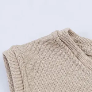Close-up detail of beige knitted vest showing ribbed neckline and soft fabric texture