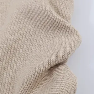 Macro detail of high-quality soft beige knit fabric texture for casual fashion top