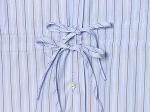 Macro view showing bow-knot tie details on a light blue vertical striped fashion shirt