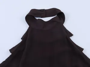 Detailopname van de donkerbruine georgette halterhals met twee knopen aan de achterkant.