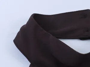 Detailweergave van de fijne stiksels en stoftextuur van een bruine georgette halter halslijn