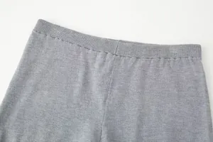 Close-up of elastic waistband on grey knitted shorts showing fine texture.