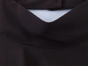 Detailopname van een donkerbruine georgette halternek die de stoftextuur laat zien.