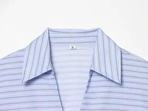 Detailed close-up view of a light blue striped shirt collar with size S woven label