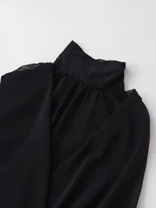 Primer plano de top negro sin mangas con cuello alto y elegante textura de tela plisada