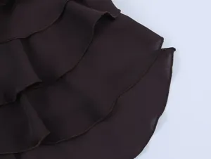 Detailopname van de elegante donkerbruine gelaagde georgette ruches van deze haltertop