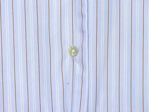 Macro view of blue and brown striped shirt fabric detailing texture and a pearl button