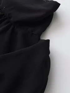 Primer plano detallado de la tela plisada negra y las costuras de un top sin mangas casual