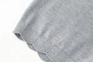 Detailed macro view of grey knitted fabric texture showing delicate scalloped edge