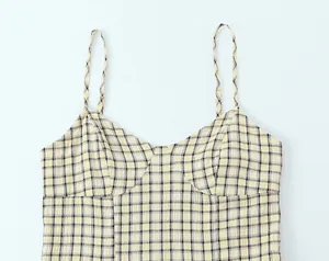 Close-up of the yellow and black plaid pattern on a camisole dress bodice detail