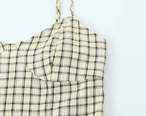 Detail of yellow plaid camisole midi dress showing the textured fabric and straps