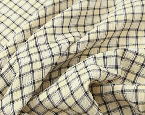 Macro detail of yellow and black plaid seersucker fabric texture for midi dress