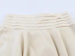 Detailed macro view of stylish layered waist decoration on cream asymmetric skirt