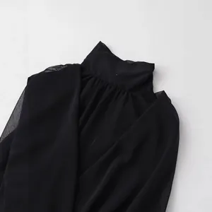 Elegante blusa negra sin mangas de cuello alto con un diseño detallado de pliegues