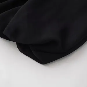 Vista detallada de la textura de tela plisada negra de alta calidad para un top sin mangas