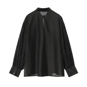 Gedetailleerd achteraanzicht van een elegante zwarte satijnen blouse met strik en plooimouwen.