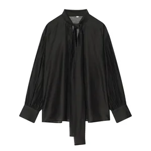 Gedetailleerde weergave van een zwarte satijnen blouse met lange mouwen en strikhals.
