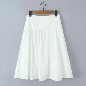 Detailed view of elegant white A-line skirt with ruffle hem and button accents