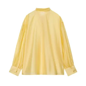 Achteraanzicht van elegante lichtgele satijnen blouse met lange mouwen en geplooide manchetten