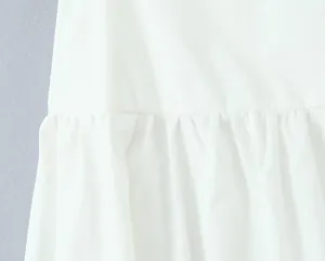 Detailed macro view showing the ruffled seam and fabric texture of a white mini A-line skirt