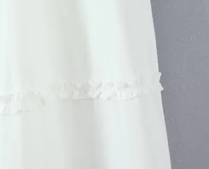 Close-up detail showing the delicate ruffle trim on a white fashion A-line mini skirt
