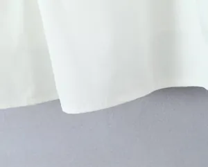 Close-up of high-quality white fabric and neat hemline stitching of a mini A-line skirt