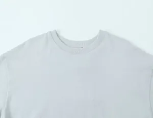 Close-up detail of a light grey crew neckline on a women's asymmetrical T-shirt top