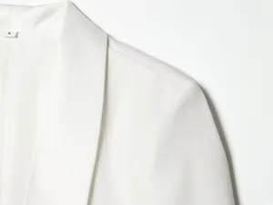 Close-up detail showing the shoulder stitching and tuxedo collar of a white blazer jacket
