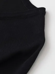 Macro de la maille côtelée noire de qualité montrant la texture fine et les coutures nettes