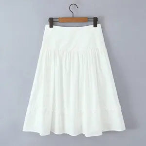 Detail view of white A-line pleated midi skirt with ruffle hem on gray background