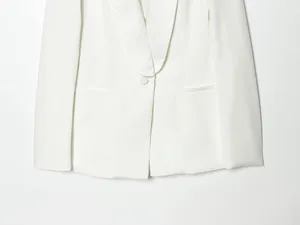 Detailed macro view of a white formal blazer featuring a luxurious satin shawl lapel