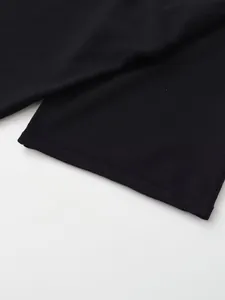 Vue macro détaillée montrant la texture douce du tricot noir et la finition de l'ourlet