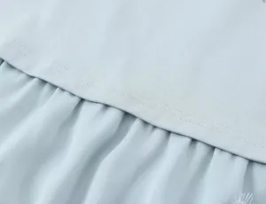 Close-up of light blue lace splicing fabric and fine stitching detail on T-shirt top