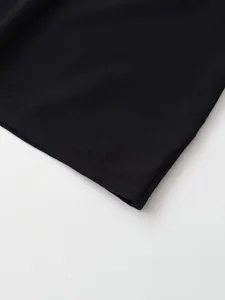 Détail en gros plan montrant la texture fine et l'ourlet d'un pull en tricot noir.