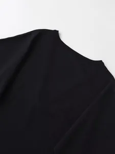 Gros plan détaillé d'un pull en maille noire montrant la texture fine et l'encolure